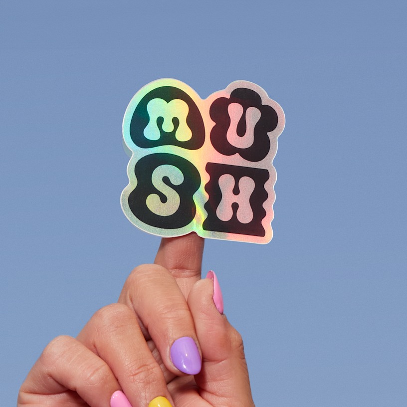 A holographic sticker cut to the shape of a handmade jewelry company’s logo.