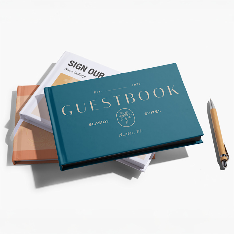A stack of guest books, one printed with the name of a hotel on the cover and the other with the name of an art gallery. 