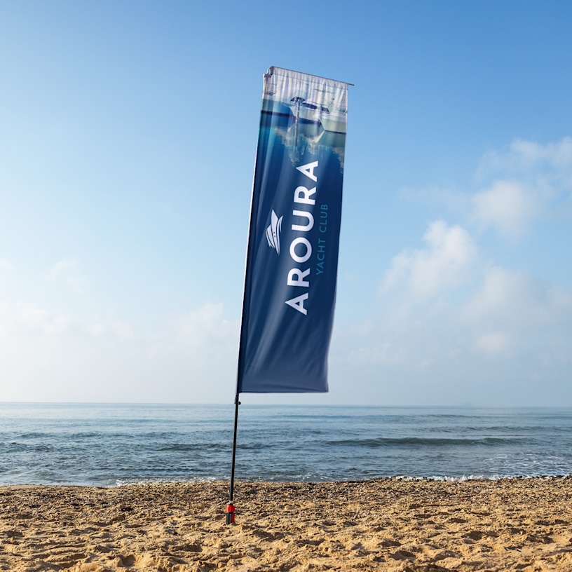 A blue and white rectangle flag set up on a beach.