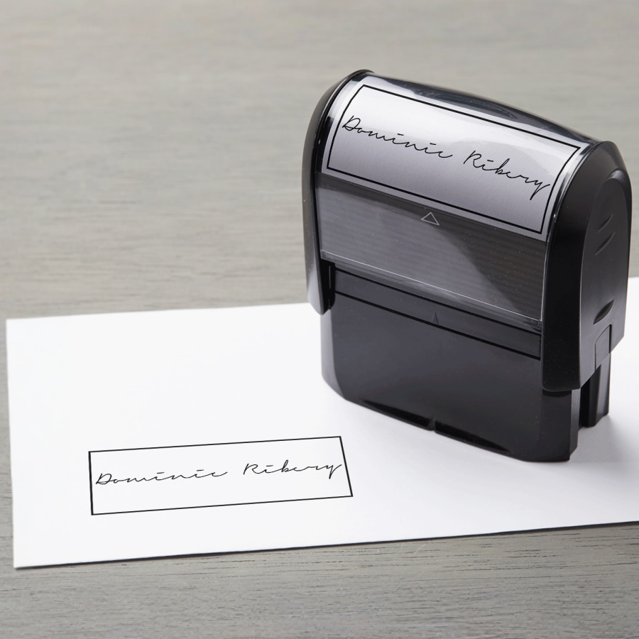 A rectangular signature stamp being used on an envelope.