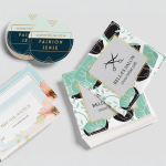 Stacks of square and circle sticker singles advertising clothing retail and salon businesses.