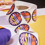 A slightly unravelled roll of labels from a handmade jewelry company.