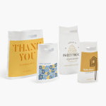 Several sizes of Die Cut Handle Bags promoting a variety of businesses.