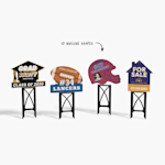 A grad hat, football, football helmet and a house yard sign on black plastic stands.