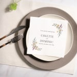 A floral napkin personalized for a wedding, with the couples’ names and wedding date. 
