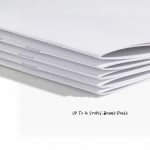 A stack of unprinted self-cover booklets, showing the stapled binding. 