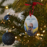 A custom ornament on a Christmas tree featuring a photo of a little girl in sunglasses.  