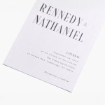 A custom wedding invitation personalized with a bold font style and pearl-finish paper stock. 