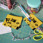 A stack of thank you postcards sitting on a crafting table.