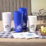 Custom stadium cups stacked on a party table, personalized with the message, “Let’s groove.”