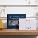 Two custom guest books displayed on a table, one personalized for a graduation party and the other for a wedding. 