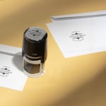 A round stamp from a florist being used to mark envelopes.