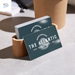 A stack of dark blue business cards for a restaurant, placed inside a wooden holder on a concrete surface, with a 48-hour delivery icon in the corner.