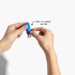 A person changing the ink pad in a small round stamp, with a note pointing out that the pad is easy to change.