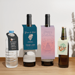 A water bottle, two wine bottles and a cider bottle displaying bottle neck tags.