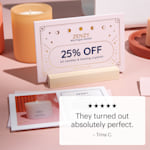 A raised foil postcard in a wooden holder on a display counter.