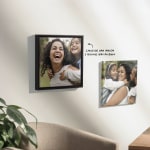 Duas telas personalizadas penduradas numa parede com fotografias de família e uma nota a indicar que existe a opção de carregar uma fotografia e, depois, adicionar uma moldura à tela. 