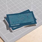 Uma pilha de cartões de visita mate dispostos num tapete de corte.