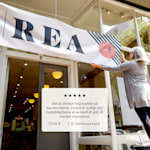 En företagsägare som hänger upp en vinylbanderoll med reklam för en rea, samt en kundrecension: ”De banderoller vi köpte var jättebra! De är tydliga och med klara färger. De är stabila och de som sitter utomhus tål vädret bra.”