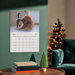 Ein aufgehängter personalisierter Wandkalender, selbst gestaltet mit dem Foto eines Golden Retrievers.  