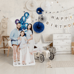 A life-size cutout of a man, woman and young girl in a birthday party setting. 
