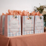 Tre sacchetti per regali personalizzati con motivi a fiori per un matrimonio e riempiti con carta velina rosa salmone.