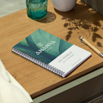 A branded wire-bound booklet promoting a day spa, with a person's name on the cover.