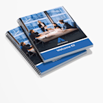 A stack of wire-bound reports and consulting materials for business services.