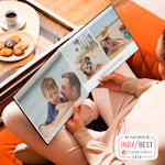 A photo book, open to pictures of a family beach holiday. 