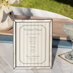 A personalized cocktail menu with a striped design inside of an elegant frame. 
