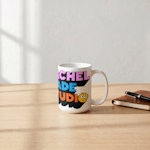 Uma caneca alta em cerâmica branca sobre uma superfície de madeira, impressa com o logótipo da marca "Home Goods" que apresenta uma lua em quarto crescente verde dentro de uma moldura arqueada. Ao lado, um caderno de couro e uma caneta.