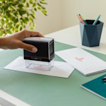 2 rectangle stamps from different companies, one with blue ink and one with black.