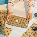 Une boîte cadeau ouverte, remplie de papier de soie soigneusement plié, personnalisé pour une boutique de beauté. 