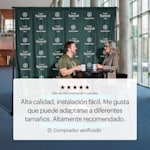 Un hombre y una mujer tomando café delante de una lona como fondo de prensa con el logotipo y el nombre de la empresa impreso repetidamente.