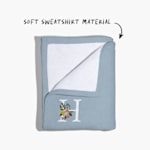 A sweatshirt blanket folded back at the corner, with a note that reads “soft sweatshirt material”. 