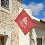 Die Flagge eines Maklerbüros weht über einem Haus.