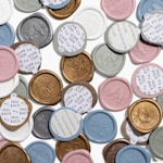 Eine Ansammlung von personalisierten Wachssiegeln mit verschiedenen Farben und Motiven.