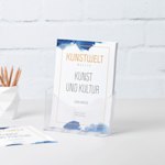 Ein DIN-A4-Flyerhalter aus Kunststoff mit Flyern einer Galerie auf einem Schreibtisch neben einem Stiftbecher.