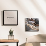 Zwei Leinwanddrucke (einer mit Rahmen, einer ohne) eines Yoga-Studios. Auf den einen ist der Name des Yoga-Studios gedruckt und auf den anderen ein Foto von Kursteilnehmenden in der Kindhaltung.