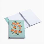 A custom wraparound spiral notebook with blank pages. The cover features illustrated oranges and a person's name. 