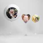 One 22" helium balloon, a 11" heart-shaped balloon with a stand and suction cup base and a 6" balloon with a plastic tabletop base.