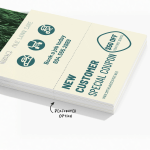 A stack of perforated door hangers featuring coupons for lawn services, with a note that it is the perforated option.