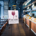 A foam board displayed on an easel inside a restaurant.