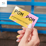 A person holding a business card from a craft store, with a 24-hour delivery icon in the corner.