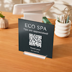 A spa metal table sign sharing a QR code for tips.