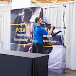 A man draping the fabric of the pop-up display over the frame.