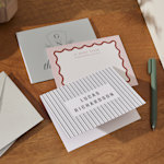 3 personalized note cards laid out on a table and featuring a variety of modern designs. 
