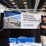 A vinyl banner promoting a construction company hanging up at a trade show.