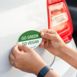 Rectangular bumper sticker advertising a dog grooming business on a white car