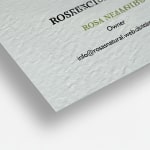 A close-up shot of textured uncoated business cards showing their square corners and canvas-like textured paper stock.